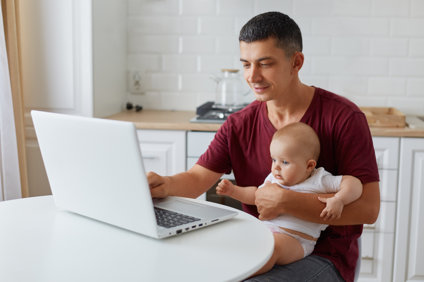 Attractive Young Single Dad Working on a Laptop Computer at Home